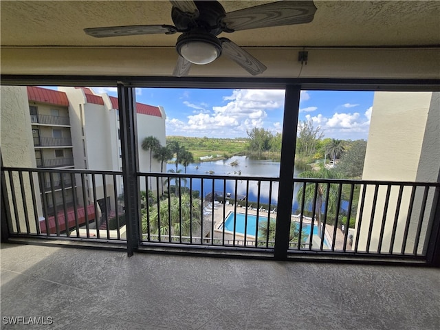 balcony featuring ceiling fan and a water view