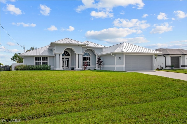 view of front of house featuring a garage, french doors, and a front lawn