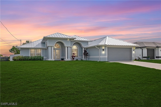 view of front of house with a yard and a garage