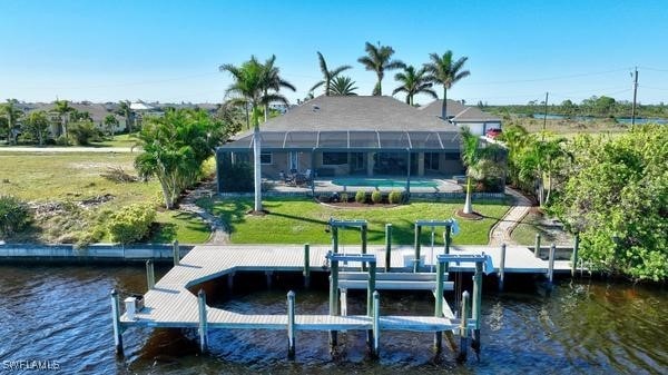 view of dock featuring a lawn, glass enclosure, and a water view