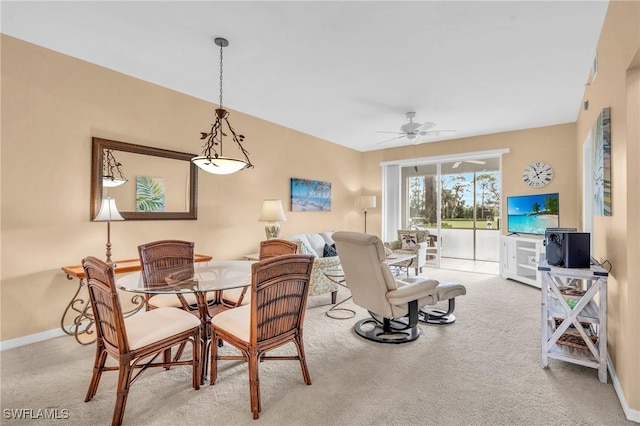 dining space with a ceiling fan, carpet flooring, and baseboards