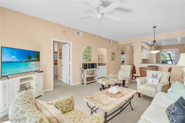 living area featuring light carpet, baseboards, visible vents, and a ceiling fan