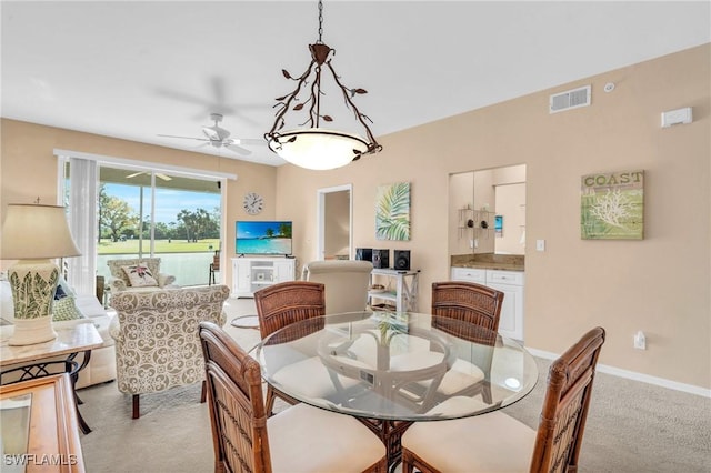 dining area featuring visible vents, ceiling fan, light carpet, and baseboards