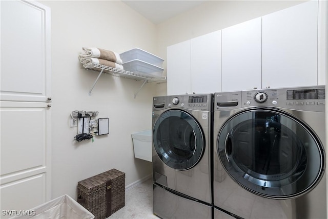 laundry room featuring cabinets and washing machine and clothes dryer