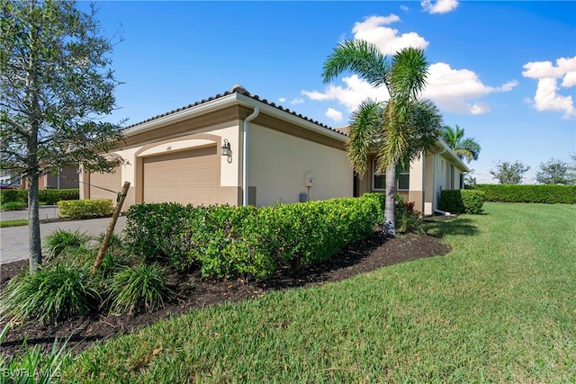 view of side of home featuring a garage and a yard