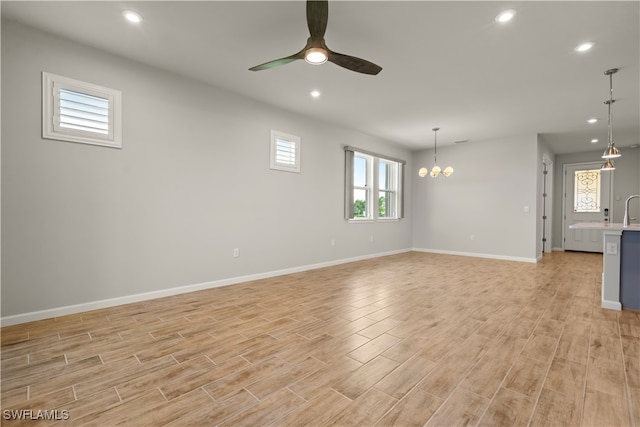 interior space with ceiling fan with notable chandelier