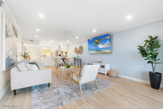 living room with ceiling fan, light hardwood / wood-style floors, and ornamental molding