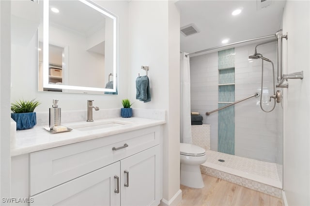 bathroom with walk in shower, crown molding, wood-type flooring, toilet, and vanity