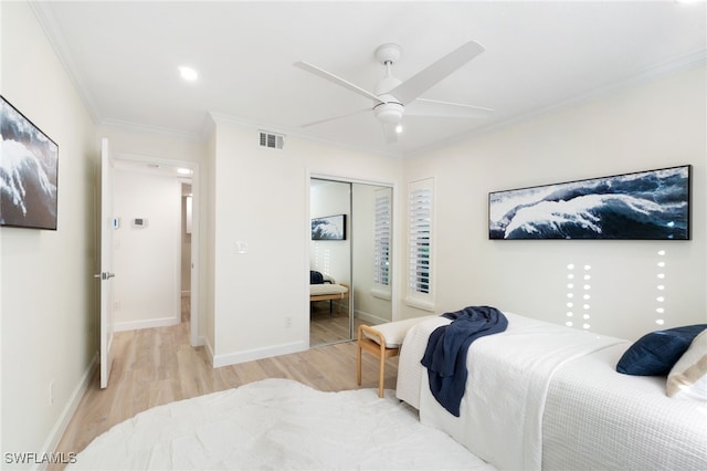 bedroom with ceiling fan, a closet, ornamental molding, and light wood-type flooring