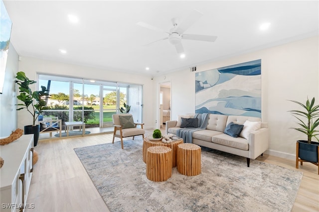 living room with ceiling fan and light hardwood / wood-style flooring