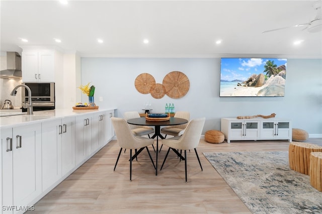 dining space featuring crown molding, ceiling fan, and light wood-type flooring