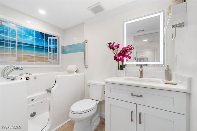 bathroom featuring vanity, toilet, and a tub