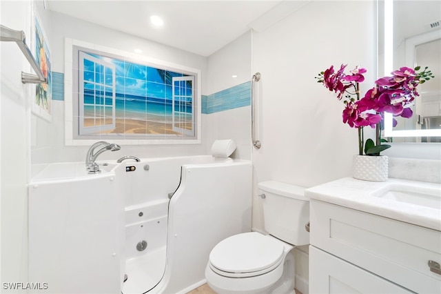 bathroom with a bathtub, vanity, and toilet