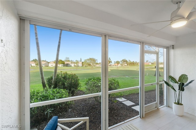 unfurnished sunroom with ceiling fan