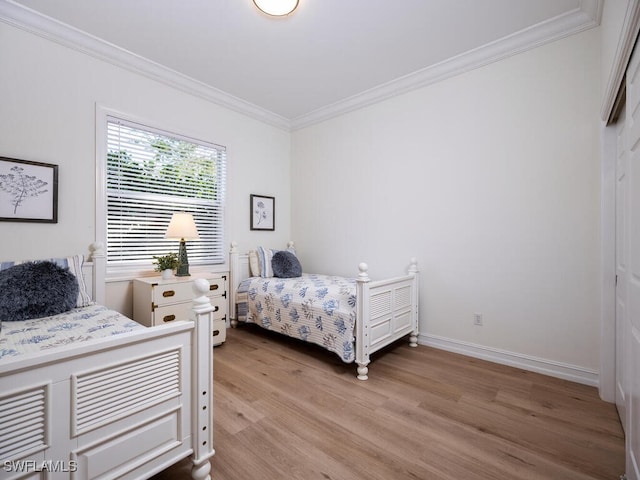 bedroom featuring crown molding and light hardwood / wood-style flooring