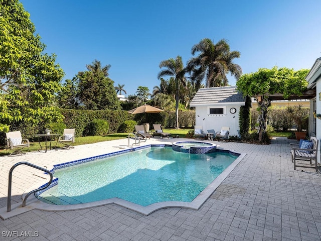 view of pool with an in ground hot tub, an outdoor structure, and a patio area