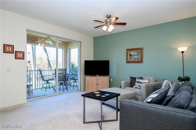 carpeted living area featuring baseboards and ceiling fan