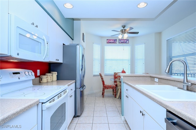 kitchen featuring white cabinets, a healthy amount of sunlight, white appliances, and sink