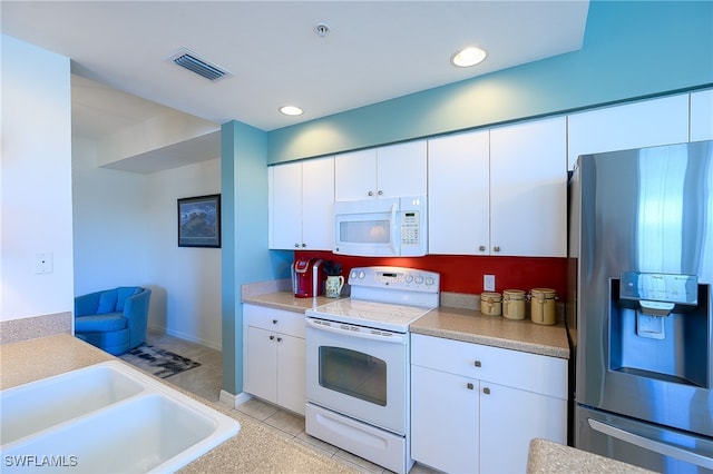 kitchen featuring white cabinets, light tile patterned floors, white appliances, and sink