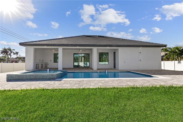 back of property featuring a swimming pool with hot tub, a yard, and ceiling fan