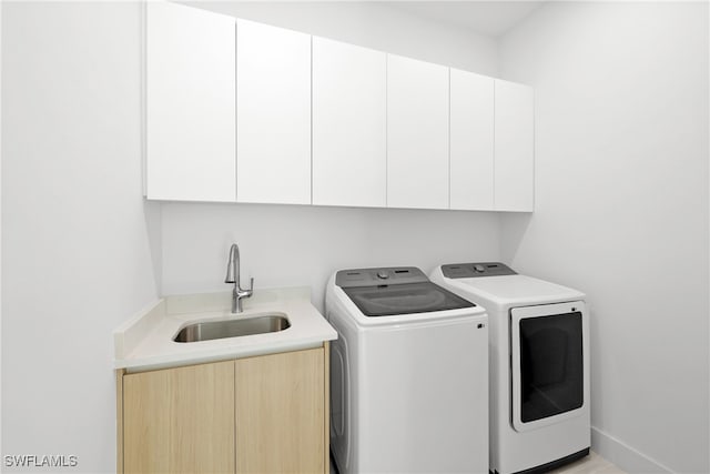 laundry room featuring cabinets, washing machine and dryer, and sink