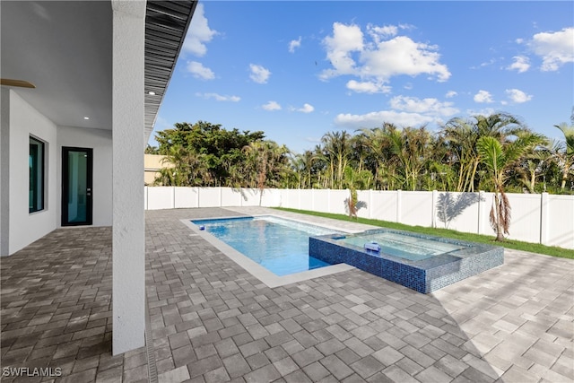 view of pool with a patio area and an in ground hot tub