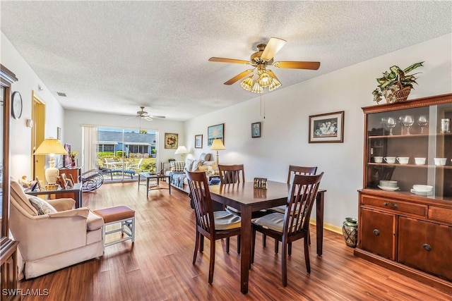 6842 Bogey Dr, Fort Myers, FL 33919 - dining space featuring a ceiling fan, a textured ceiling, and wood finished floors
