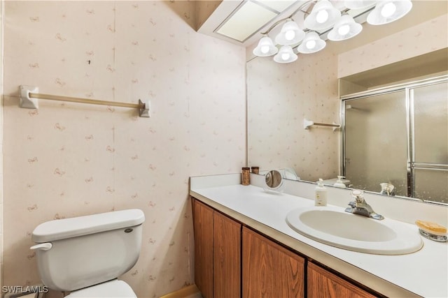6842 Bogey Dr, Fort Myers, FL 33919 - full bathroom featuring wallpapered walls, vanity, toilet, and a shower with shower door