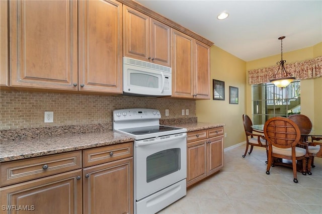 14531 Abaco Lakes Dr Unit 103, Fort Myers, FL 33908 - kitchen with white appliances, backsplash, light tile patterned flooring, decorative light fixtures, and brown cabinets