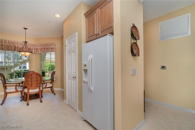 14531 Abaco Lakes Dr Unit 103, Fort Myers, FL 33908 - kitchen with white fridge with ice dispenser, brown cabinets, light tile patterned floors, pendant lighting, and recessed lighting