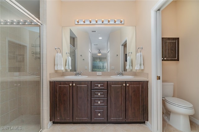 bathroom featuring vanity, tile patterned floors, ceiling fan, toilet, and a shower with shower door