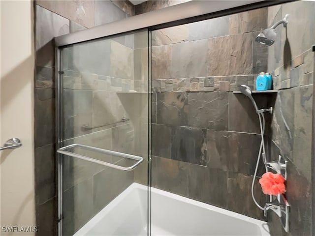 bathroom with bath / shower combo with glass door