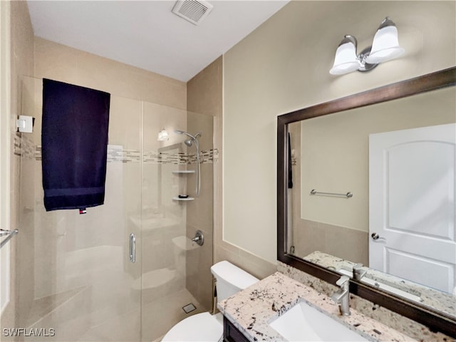 bathroom with vanity, toilet, and a shower with shower door