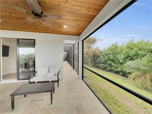 sunroom featuring ceiling fan and wooden ceiling