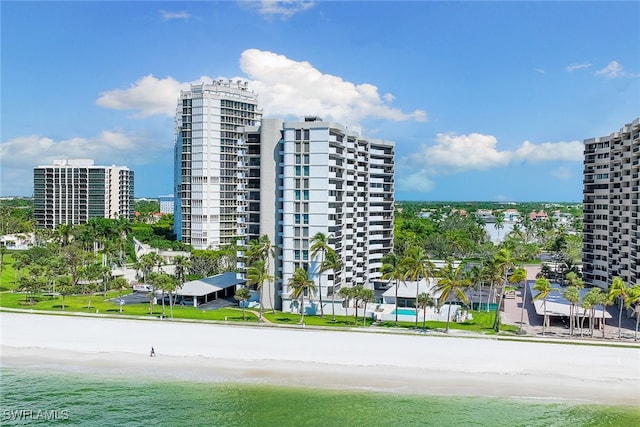 view of building exterior featuring a water view and a view of the beach