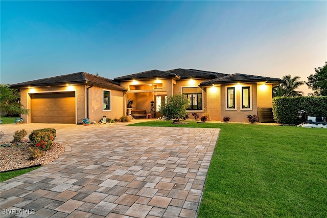 prairie-style house with a yard and a garage