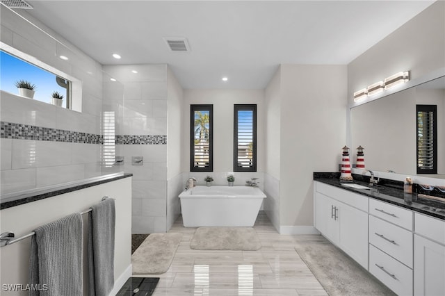 bathroom featuring vanity and shower with separate bathtub