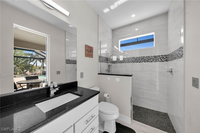 bathroom with tiled shower, hardwood / wood-style floors, vanity, and toilet