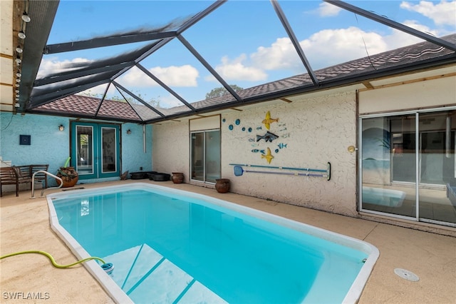 view of swimming pool with a lanai, a patio, and french doors