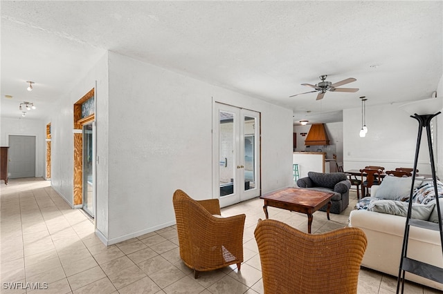 living room featuring ceiling fan, french doors, light tile patterned floors, and a textured ceiling