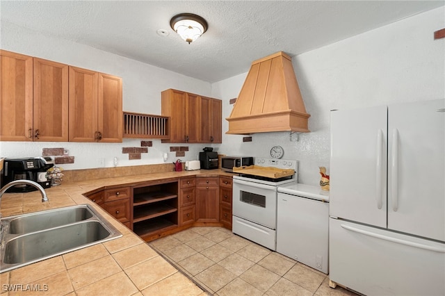 kitchen with custom exhaust hood, a textured ceiling, white appliances, sink, and light tile patterned flooring