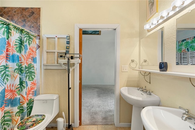 bathroom featuring tile patterned floors, a shower with curtain, toilet, and double sink