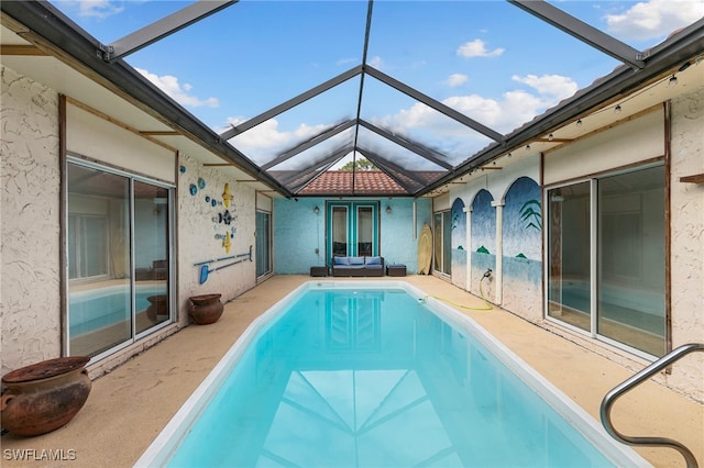 view of pool with glass enclosure and a patio