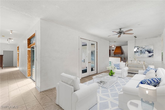 tiled living room featuring ceiling fan, a textured ceiling, and french doors