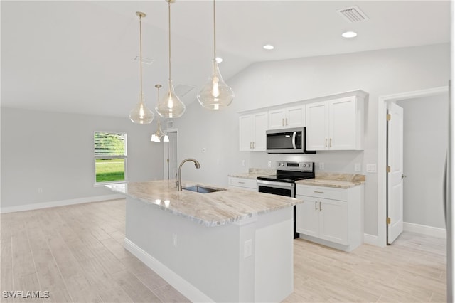 kitchen featuring stainless steel appliances, vaulted ceiling, decorative light fixtures, a center island with sink, and white cabinets