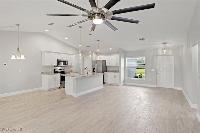 kitchen with pendant lighting, white cabinetry, stainless steel appliances, and an island with sink