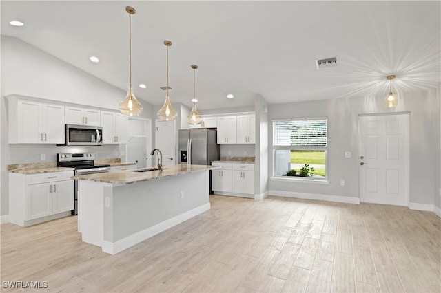 kitchen with white cabinets, appliances with stainless steel finishes, decorative light fixtures, and a center island with sink