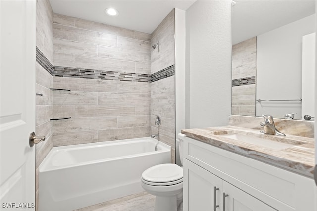 full bathroom with tiled shower / bath combo, toilet, and vanity