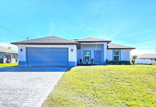 view of front of home with central AC, a front yard, and a garage