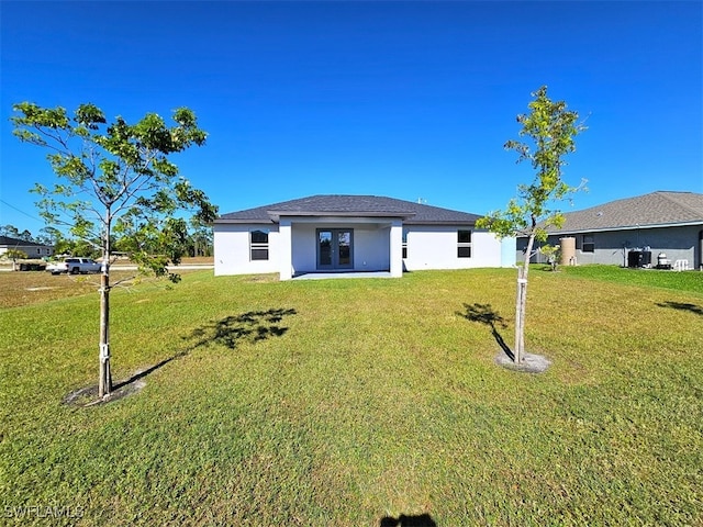 rear view of property with french doors and a yard